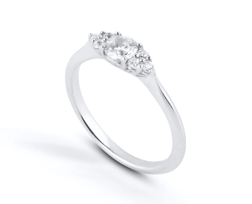 Sundre är en unik diamantring som kombinerar tidlös elegans med symbolik och briljans. Den större mittdiamanten omges av sex mindre i ett glittrande kluster som formar livets öga – en symbol för skydd, klarhet och inre styrka.